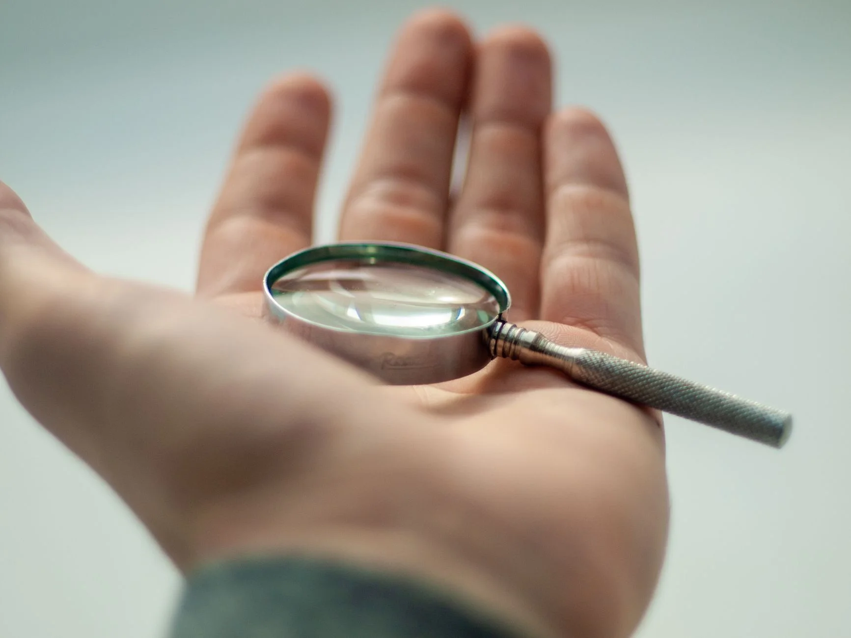 A magnifying glass resting over printed documents, symbolizing a close audit of duplicate pages