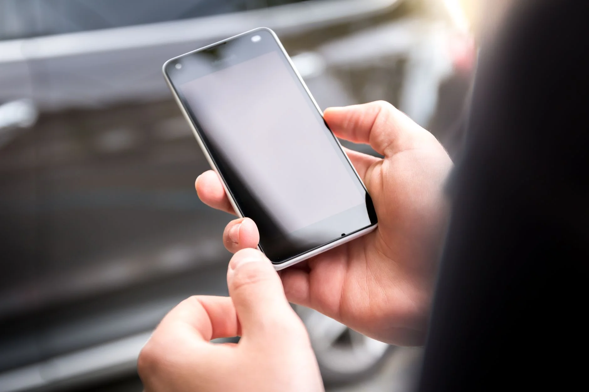 A hand holding a smartphone displaying an app screen
