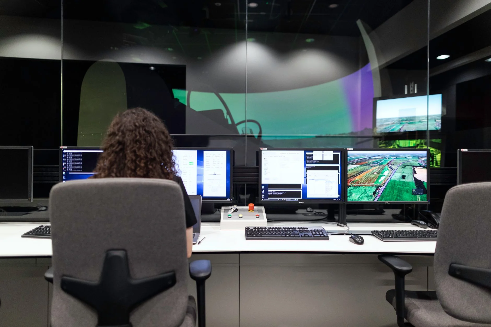A network operations center wall of monitors showing system status dashboards