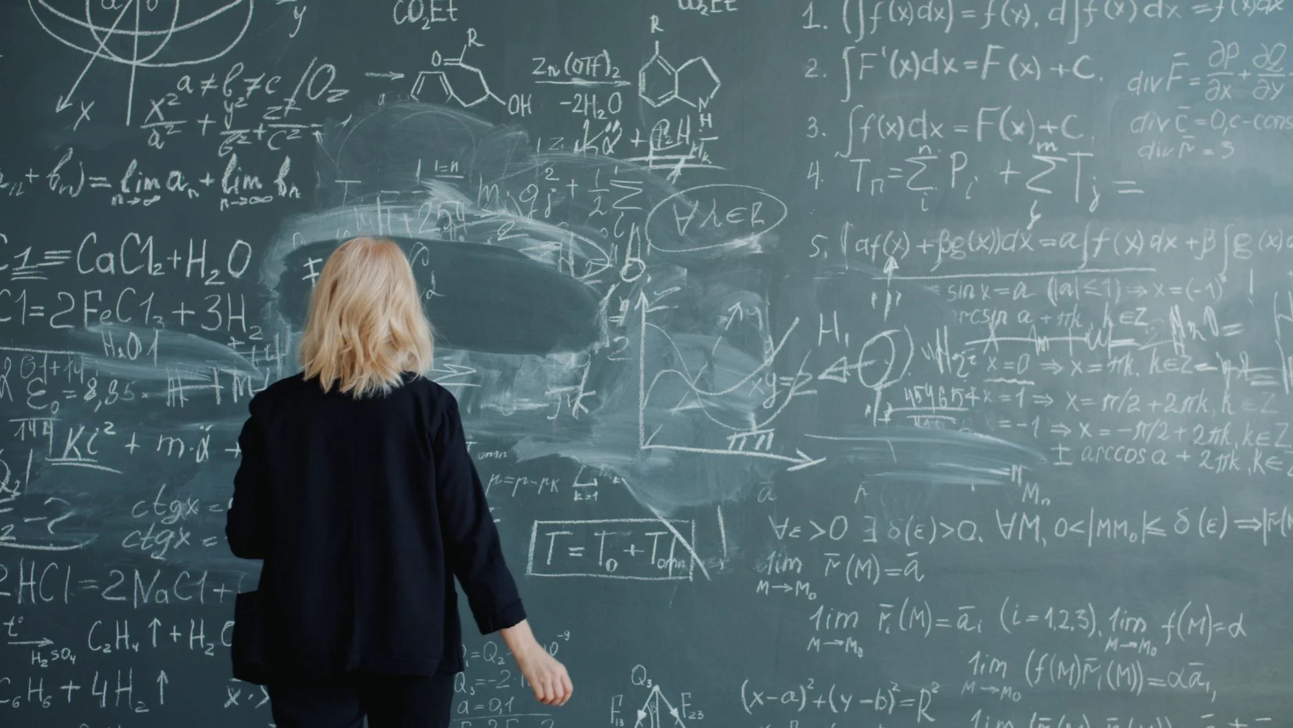 A chalkboard covered in handwritten formulas and diagrams