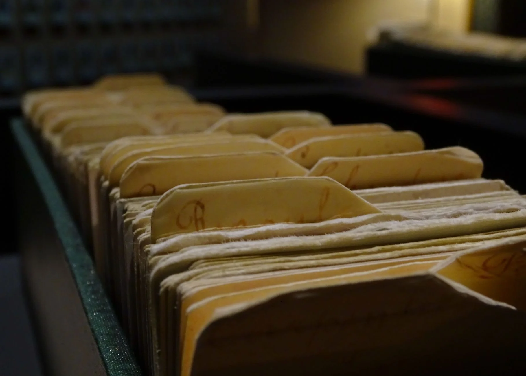 Rows of wooden library card catalog drawers with brass handles