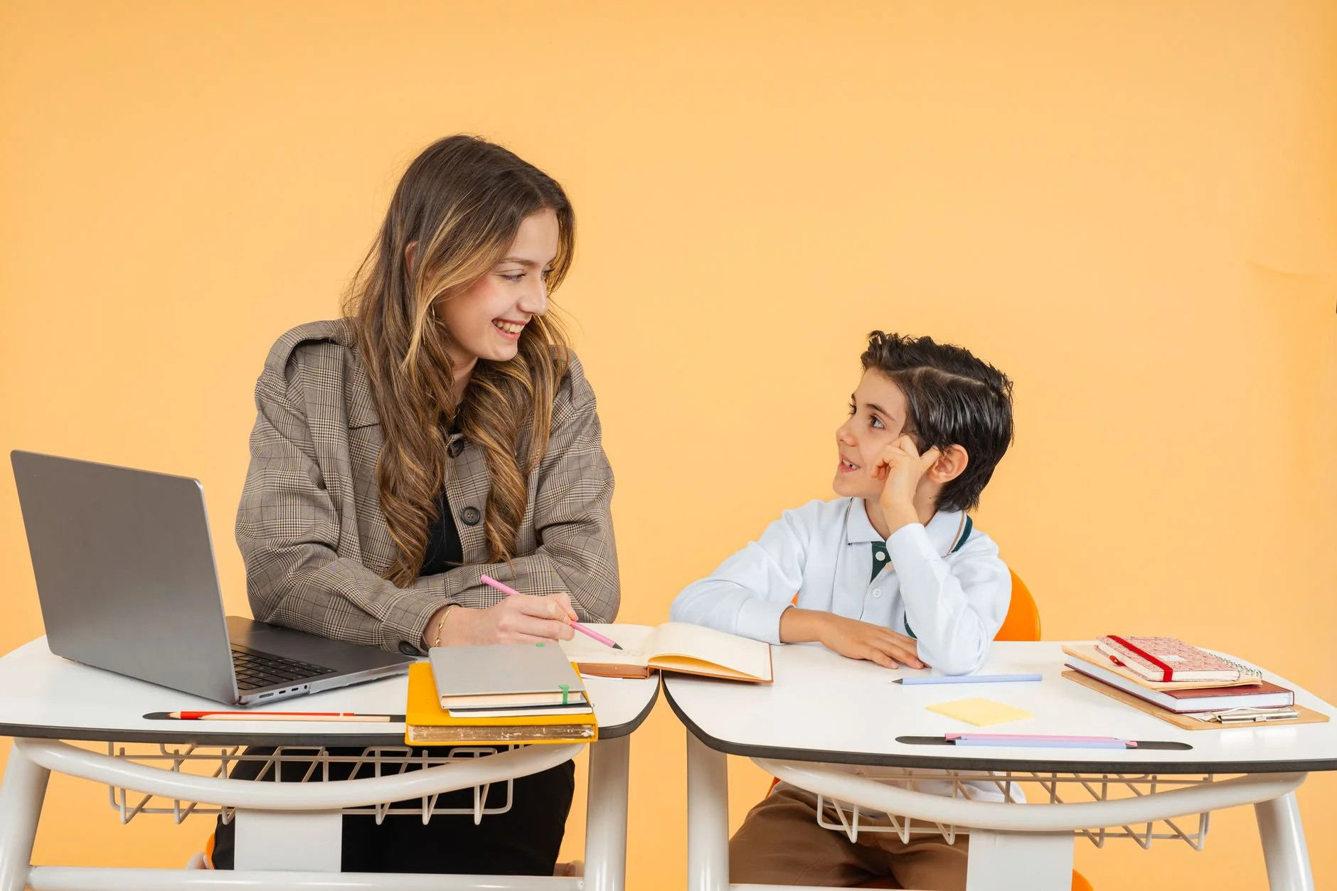 A senior engineer and a junior colleague reviewing notes together at a whiteboard